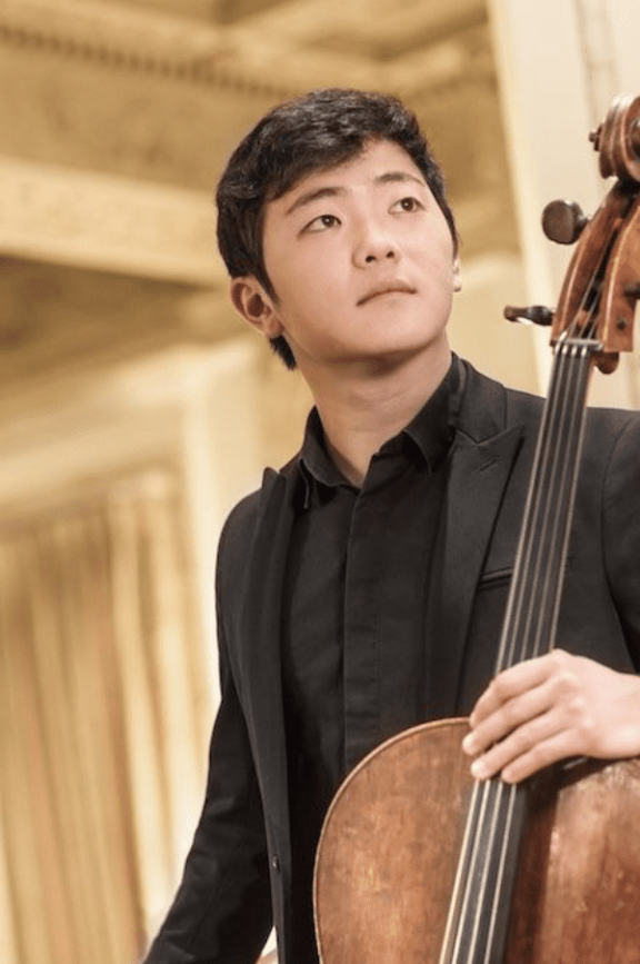 an image of man holding a cello