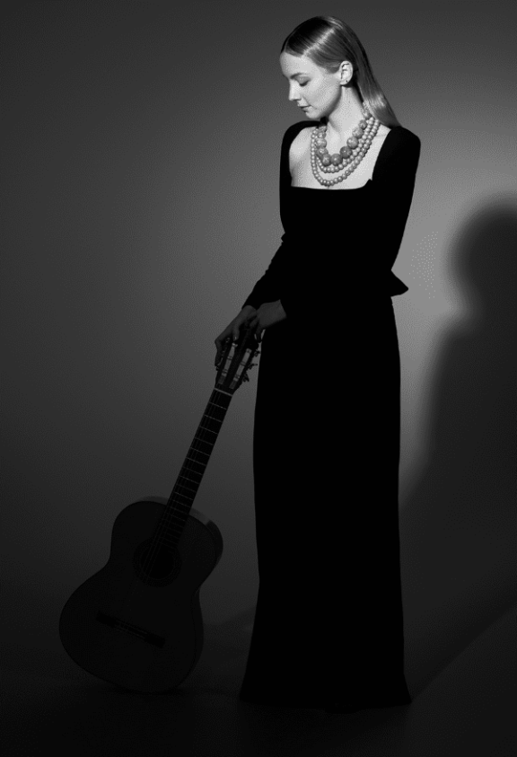 a black and white image of a woman with a guitar