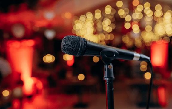an image of a microphone in front of a red and gold background