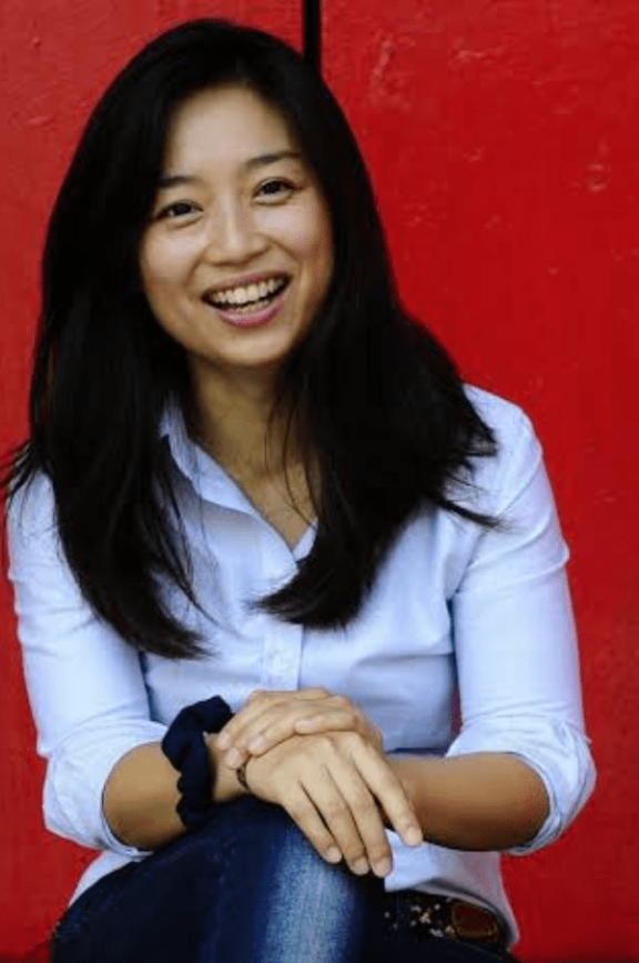 an image of a woman sitting in front of a red background