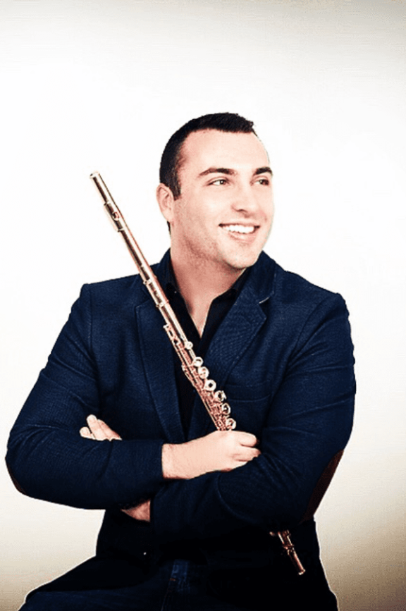 a picture of a man seated, holding a flute