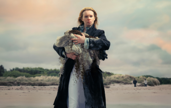 women holding something walking on beach