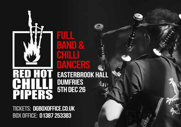 a bagpiper stands with his back to the camera