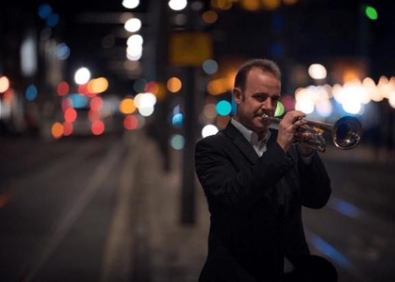 a man in a suit playing a trumpet