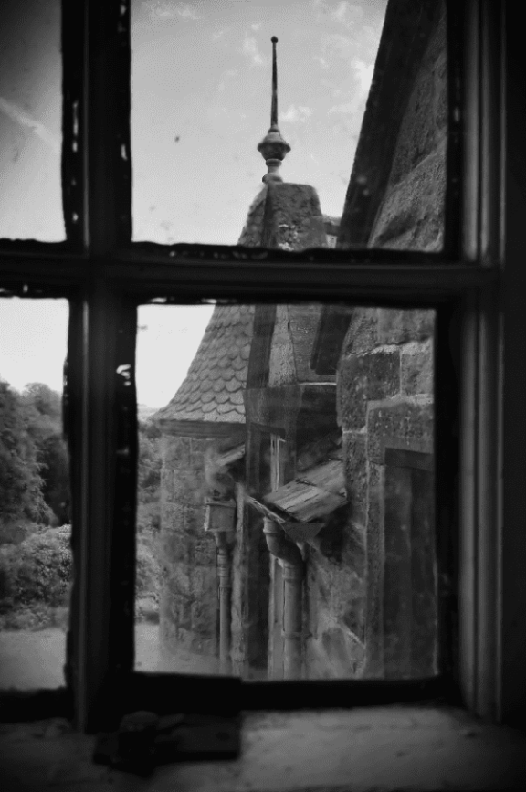 the view of a turret looking out of a window at Shambellie House in black and white