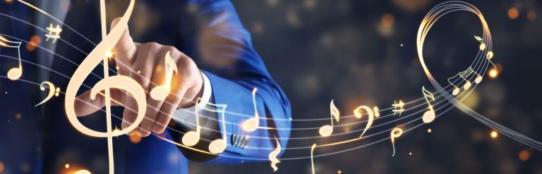 A man touches animated sparkling enlarged musical notes.