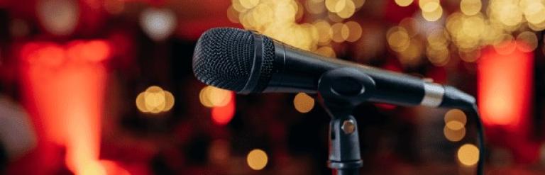 an image of a microphone in front of a red and gold background
