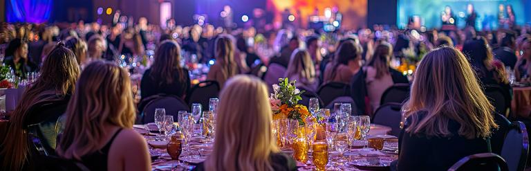 an image of a crowd of people sitting around tables with drinks