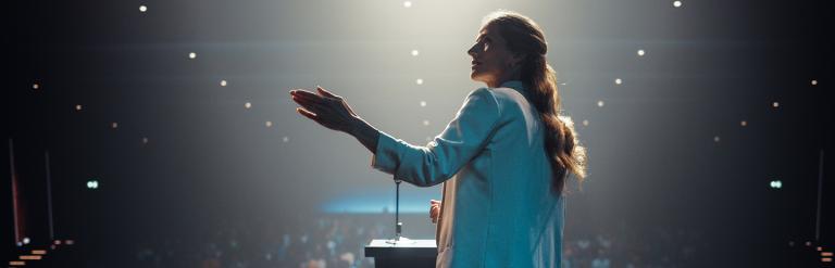 an image of a woman talking on stage